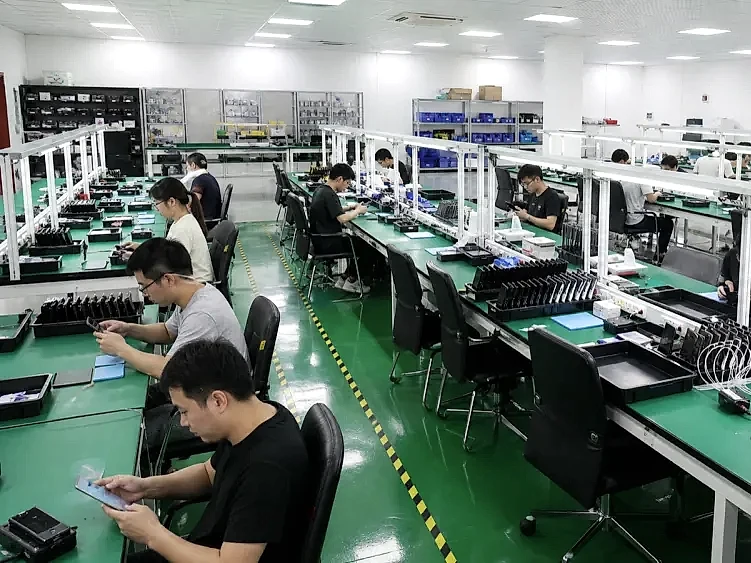 IAG's refurbishment floor, with technicians at rows of green ESD benches